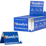 A box of Randy’s Classic Wired Rolling Papers, featuring the brand’s signature blue packaging with white and silver accents. The display box is open, revealing multiple packs inside, while a single pack is showcased in the foreground. The design highlights the product’s ease of use with the slogan "Roll, Pass, Enjoy," reinforcing Randy’s reputation as the original wired rolling paper brand.